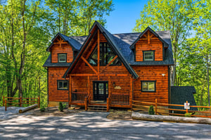 Beautiful log cabin surrounded by lush forest, featuring rustic wood architecture and peaceful mountain retreat atmosphere.