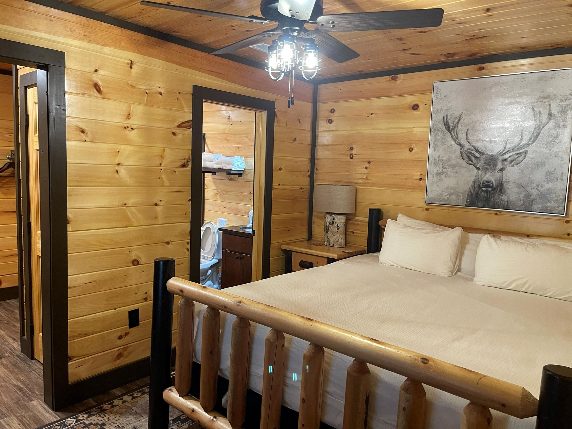 Drift off in this warm cabin bedroom with rustic log furnishings, glowing wood tones, and soft linens inviting your most peaceful nights rest.
