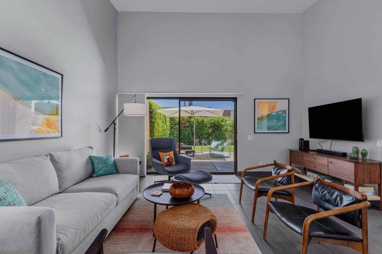 Living room has direct patio access, smart TV, ample seating, and openconcept living space.