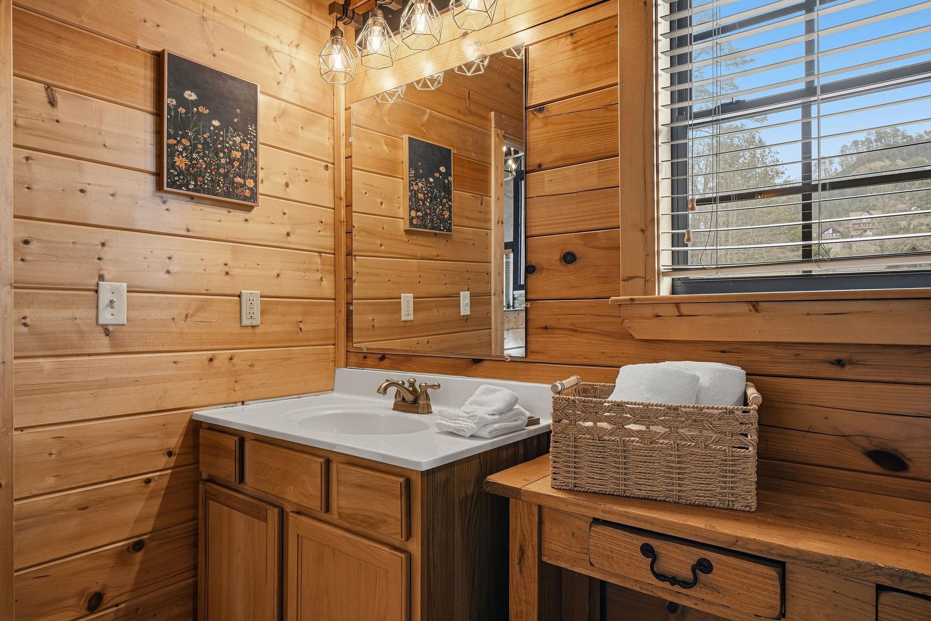 Warm wood surrounds you in this charming bathroom, where rustic cabin vibes meet modern comfort and fluffy towels await your arrival.