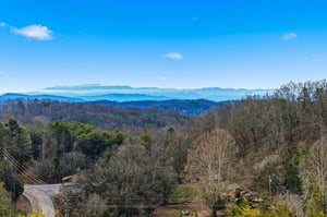 Stunning mountain vista stretches across rolling blue ridges under a bright sky, showcasing the propertys elevated location in this scenic region.