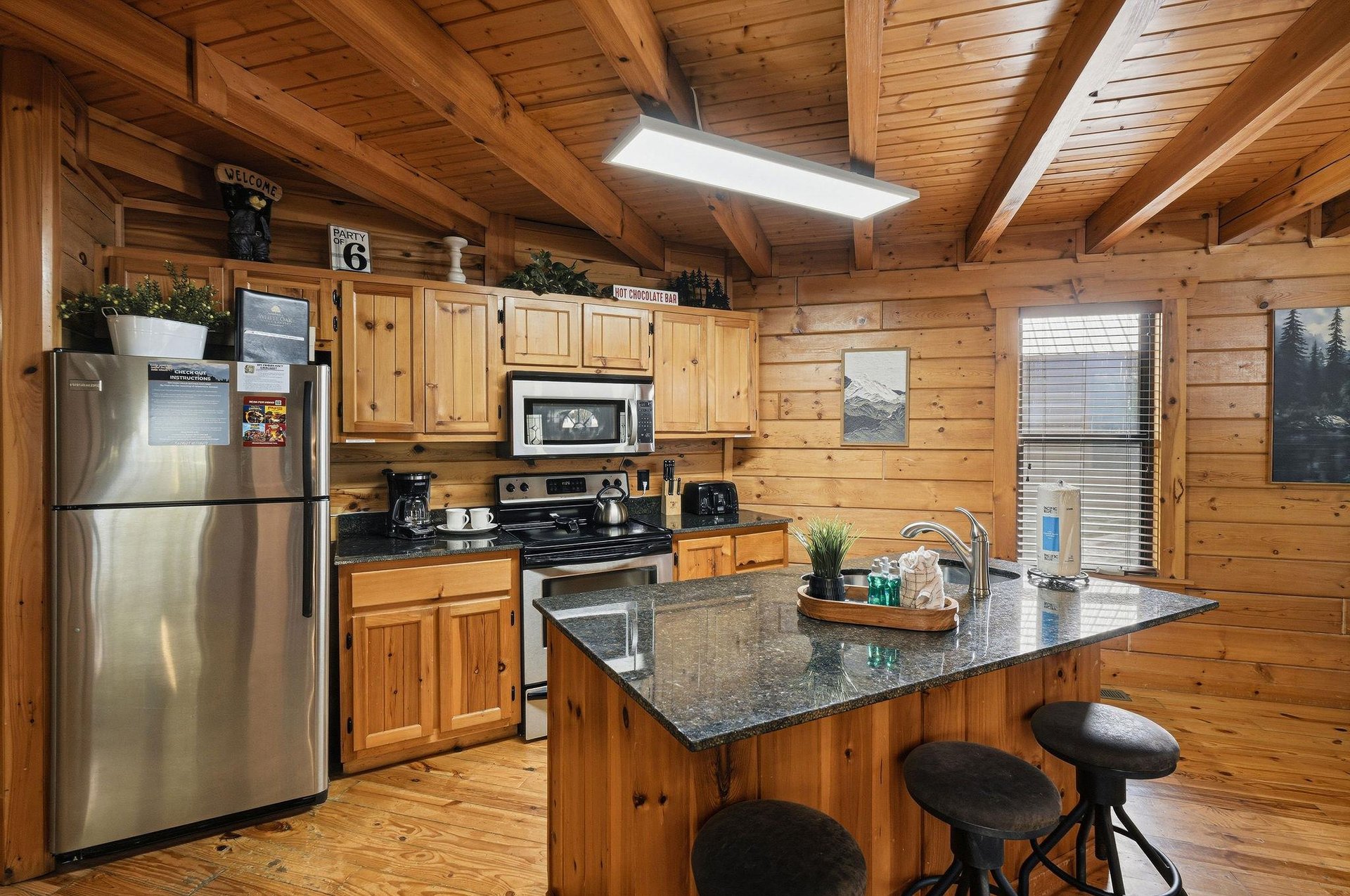 Your cozy cabin kitchen invites you to cook with warm wood beams overhead and granite counters perfect for morning coffee prep.