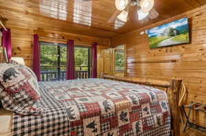 Sink into your cozy log cabin bedroom, where rustic charm meets comfort. The handcrafted bed and warm wood walls invite peaceful nights, while views of the surrounding forest create your private mount