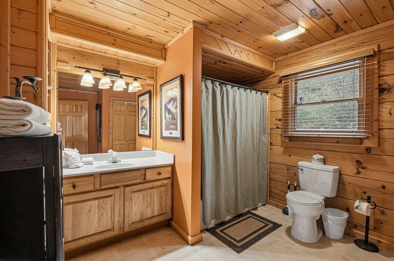 Step into your rustic sanctuary where warm wood surrounds you in comfort, complete with fluffy towels and thoughtful touches.