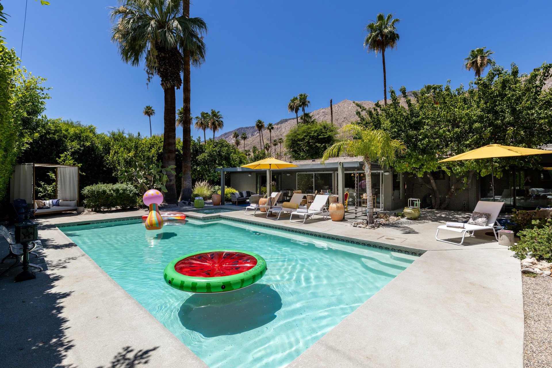 Entertainers backyard with outdoor seating, private pool and spa, sun loungers, cabana, and outdoor dining space.
