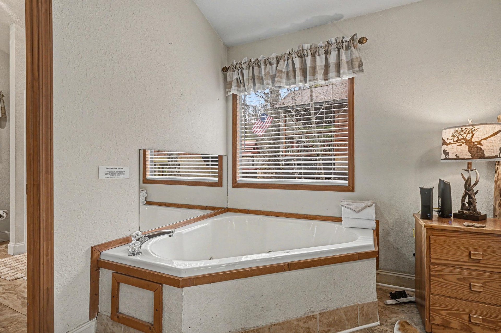 Sink into your private soaking tub surrounded by warm wood trim and natural light filtering through charming valances.