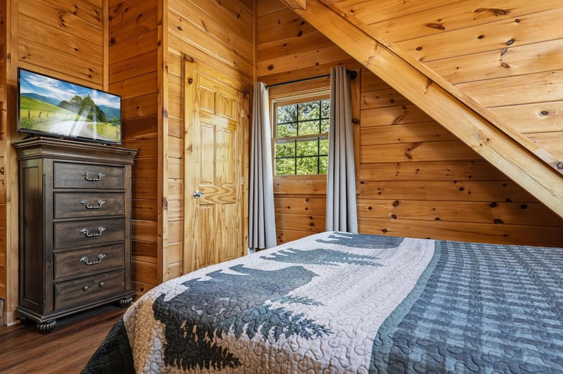 Rest peacefully in your rustic wooden bedroom with vaulted ceilings and forest views through your private window.
