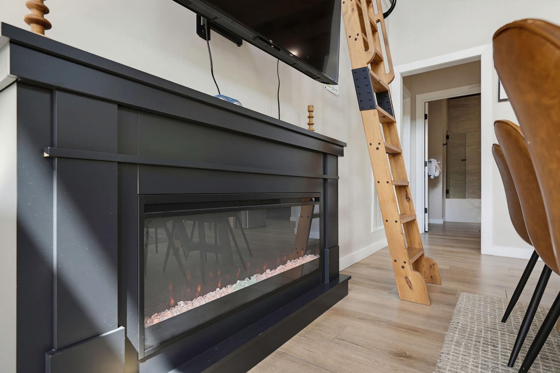 Cozy up by your modern electric fireplace, a stylish focal point for relaxing evenings after your adventures. The unique ladder adds charm and leads to extra sleeping space above.