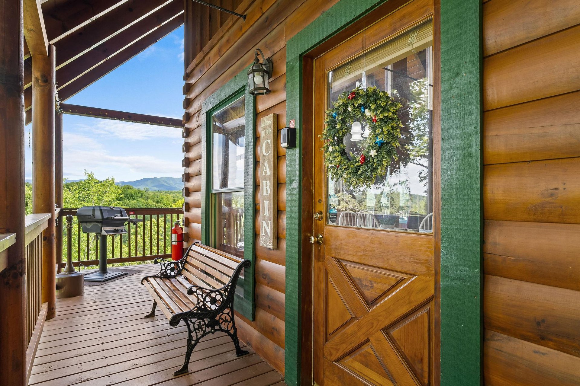 Front door of Bear Sunrise cabin with bench and grill
