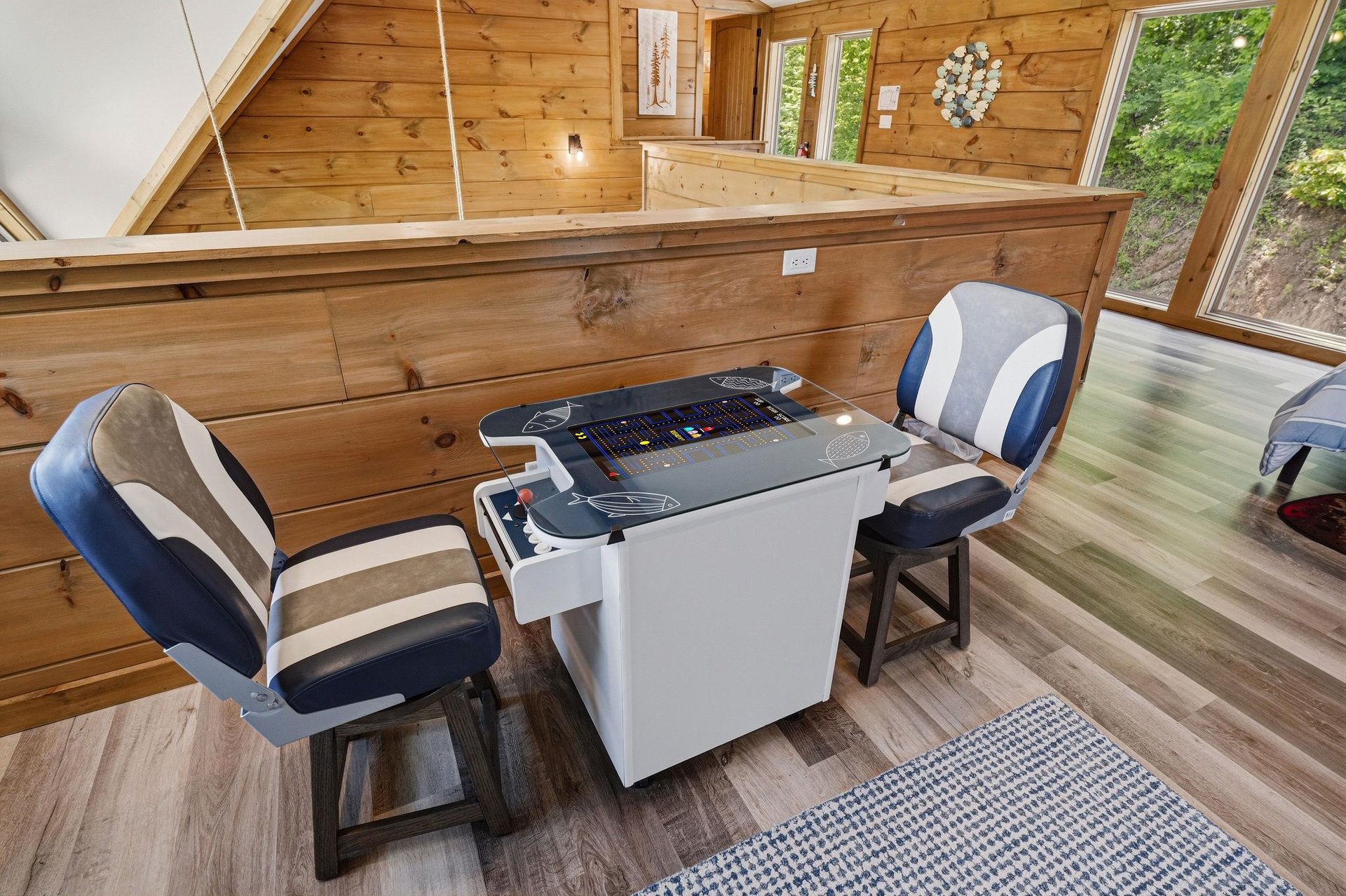 Challenge friends to retro arcade games in your cozy woodpaneled game room with forest views streaming through the windows.