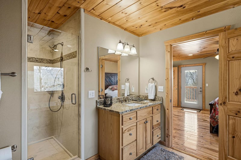 Pamper yourself in this luxurious mountain bathroom featuring a spalike shower, granite vanity, and stunning natural wood finishes throughout.