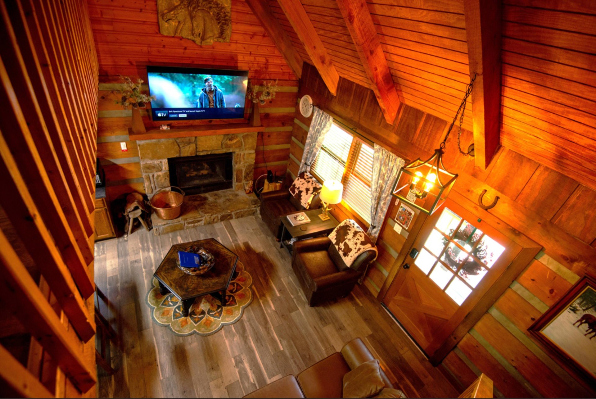 Cozy up in this stunning rustic cabin with soaring vaulted ceilings, stone fireplace, and comfortable seating perfect for movie nights.