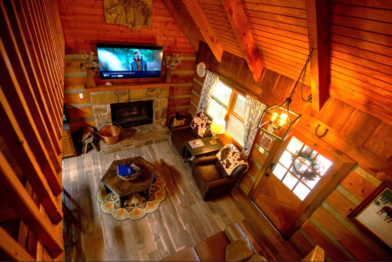 Cozy up in this stunning rustic cabin with soaring vaulted ceilings, stone fireplace, and comfortable seating perfect for movie nights.