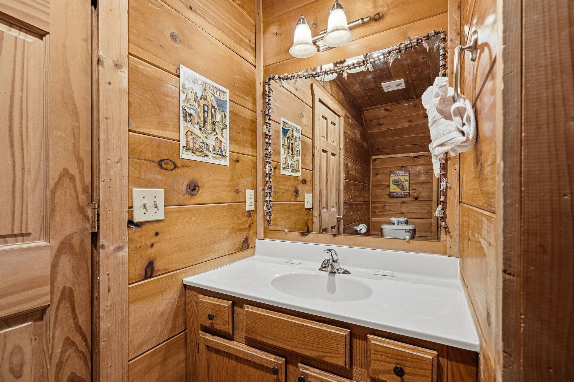Step into your cozy cabin bathroom, where warm wood walls and rustic charm create the perfect mountain retreat atmosphere.