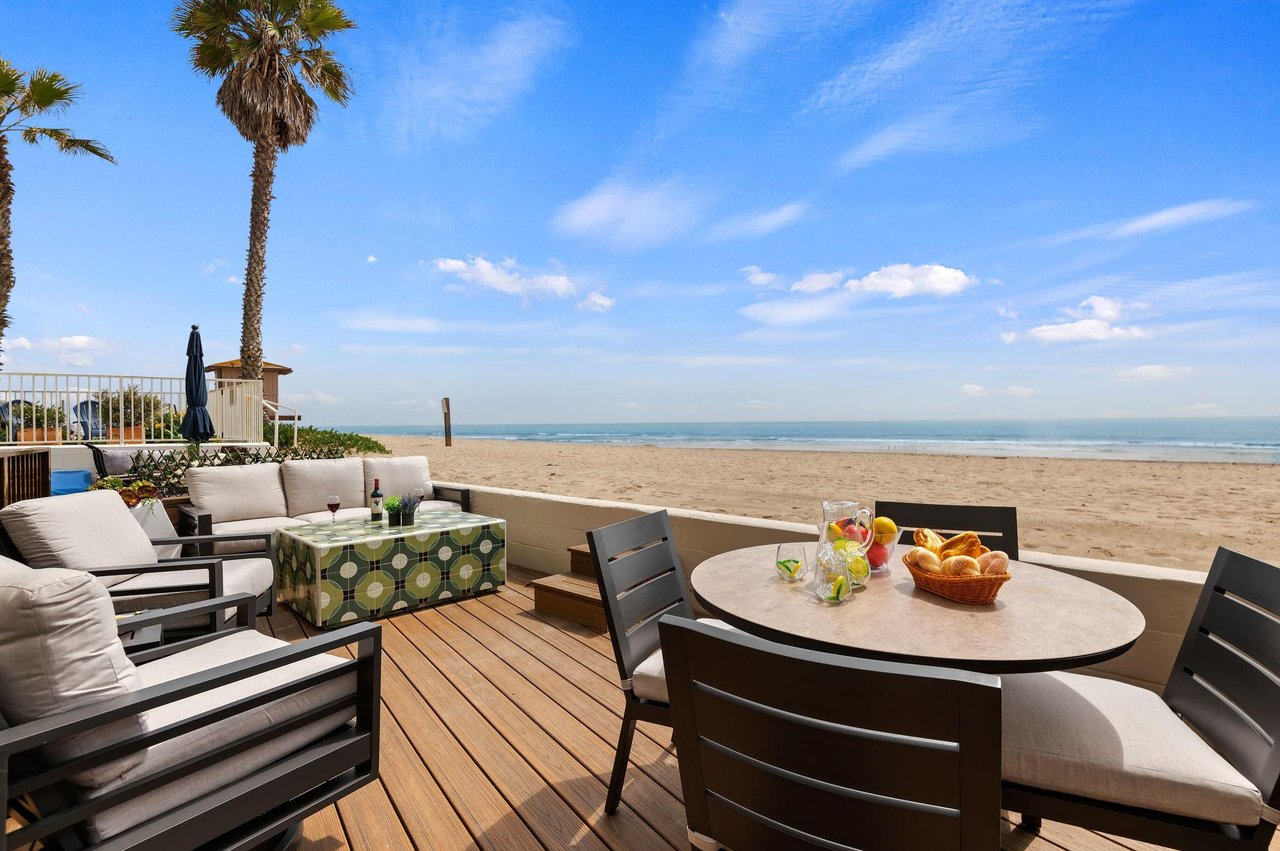 Toes in the sand Deck with comfortable couch, chairs, and dining area.