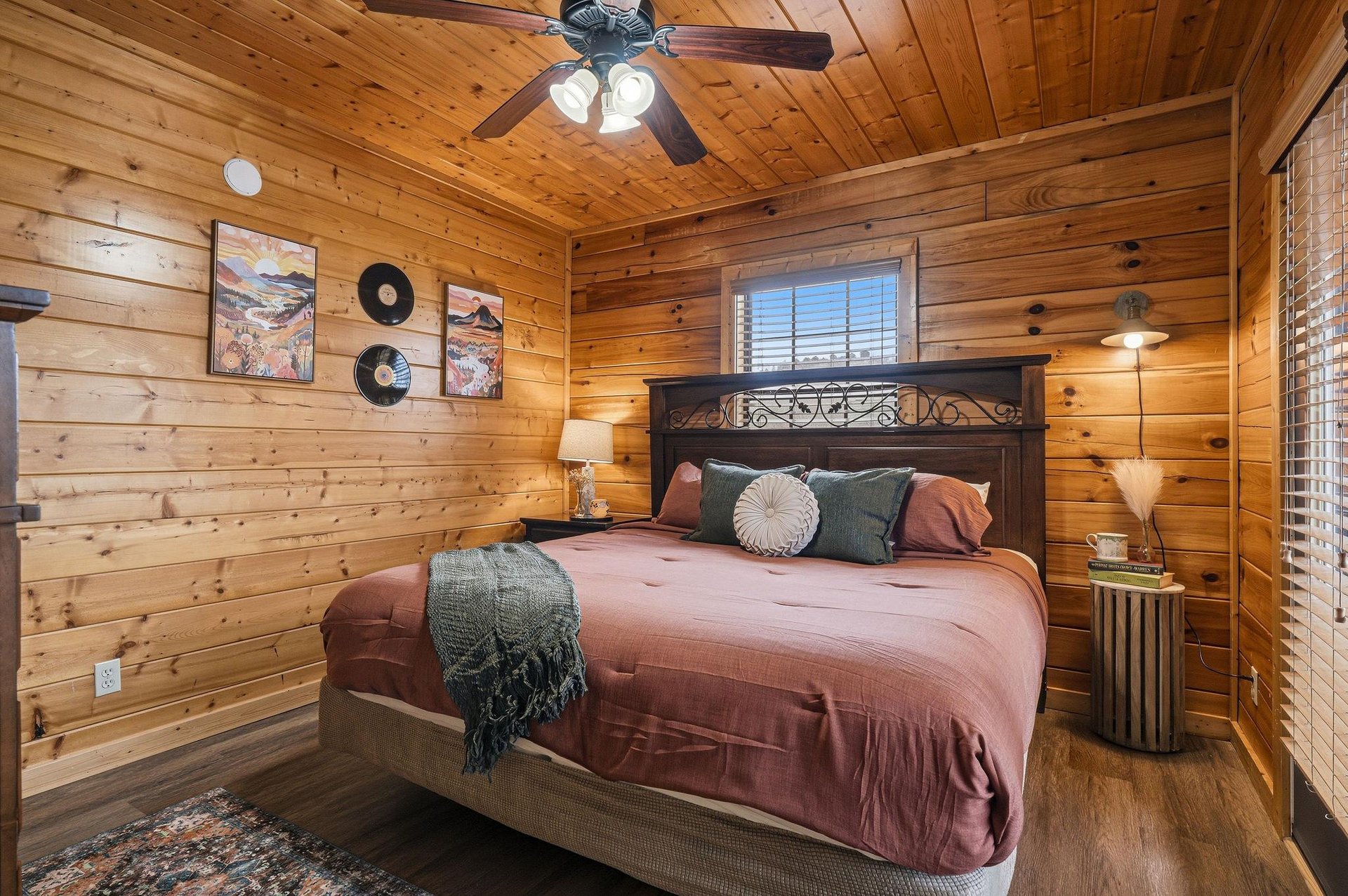 Sink into this cozy cabin bedroom where rustic wood walls create warmth and vinyl records add vintage charm to your peaceful retreat.