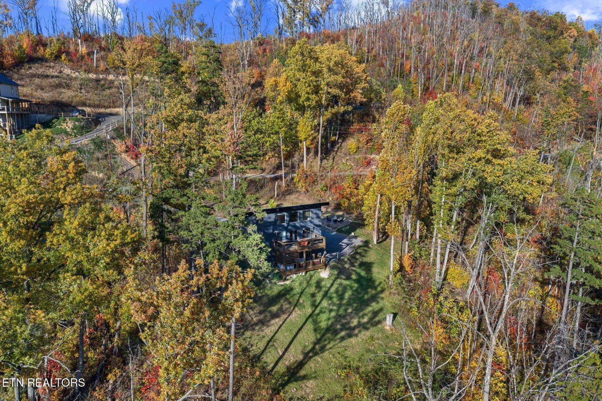 Charming mountain retreat nestled among vibrant autumn foliage, surrounded by towering aspens and colorful fall trees.
