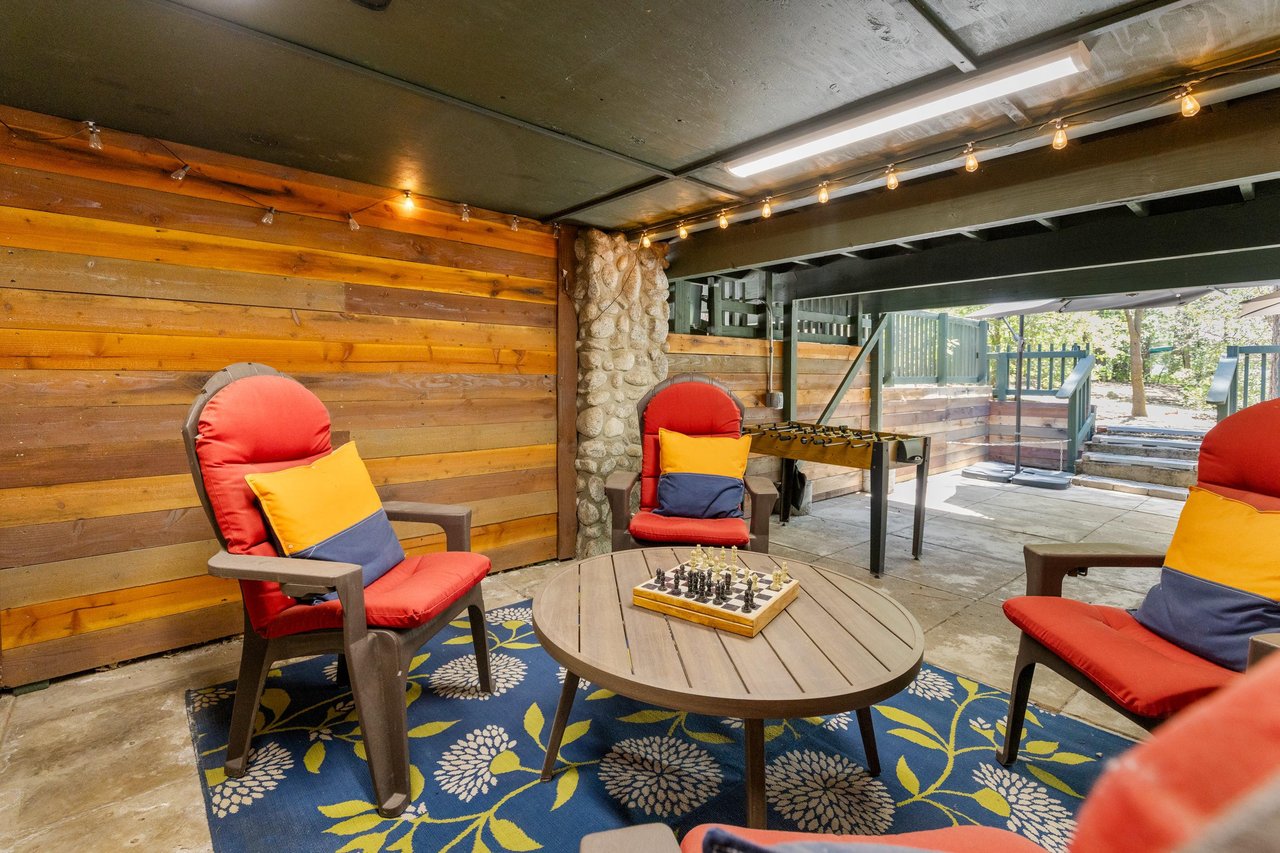 Below the deck is another outdoor seating area with games.