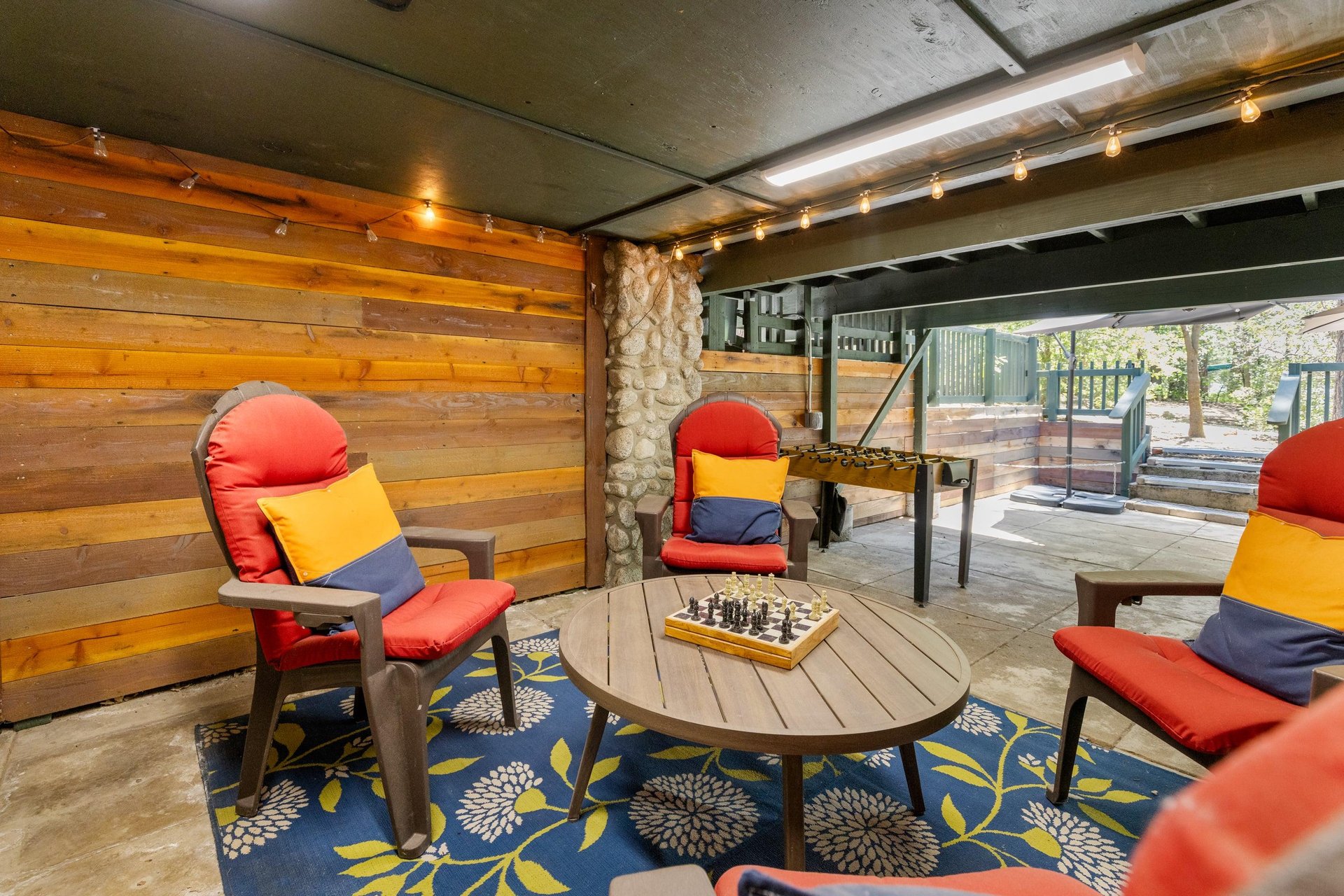 Below the deck is another outdoor seating area with games.