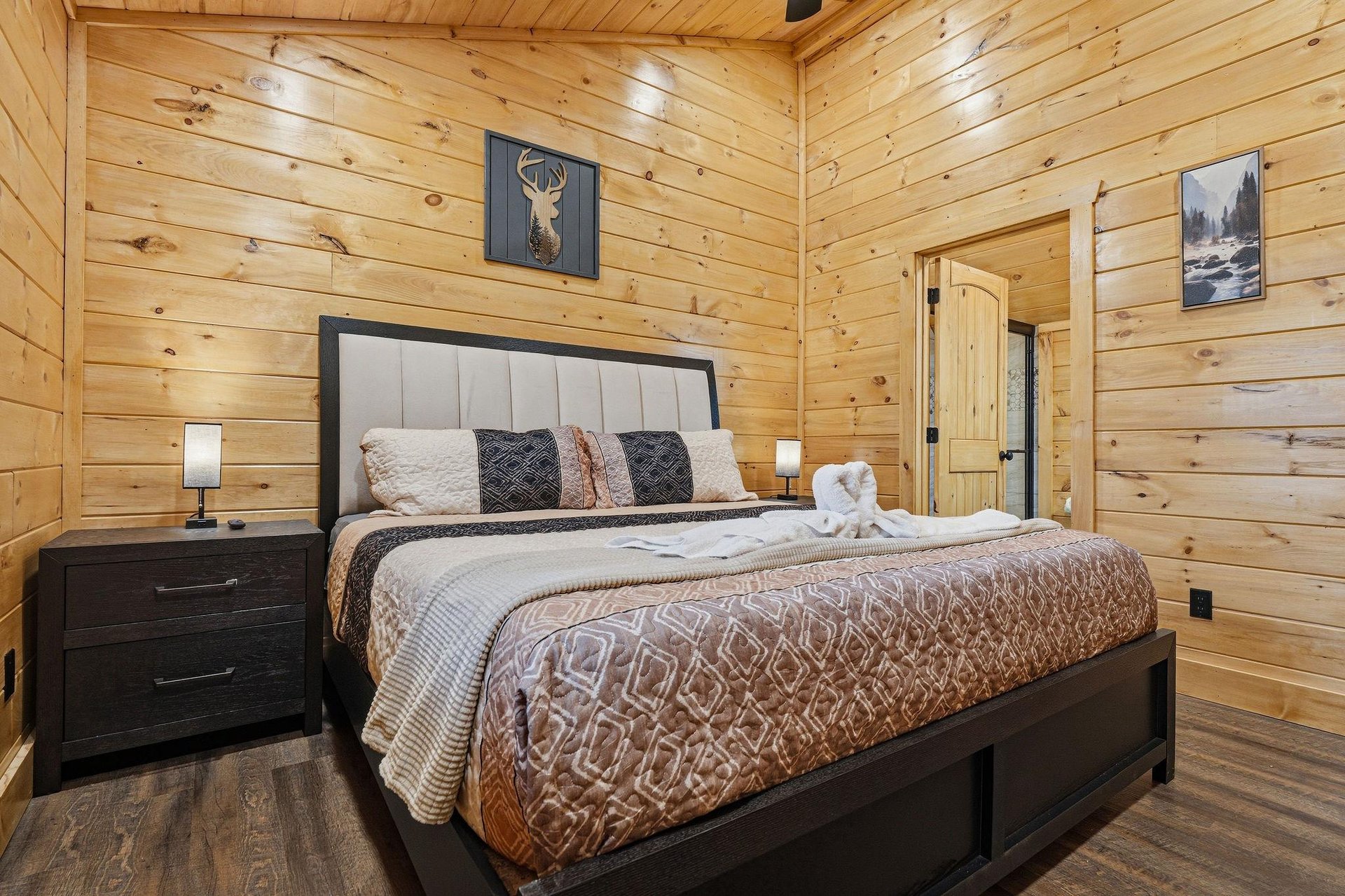 Retreat to your cozy log cabin bedroom, where rustic wood walls create warmth and the plush bed awaits your peaceful nights rest.