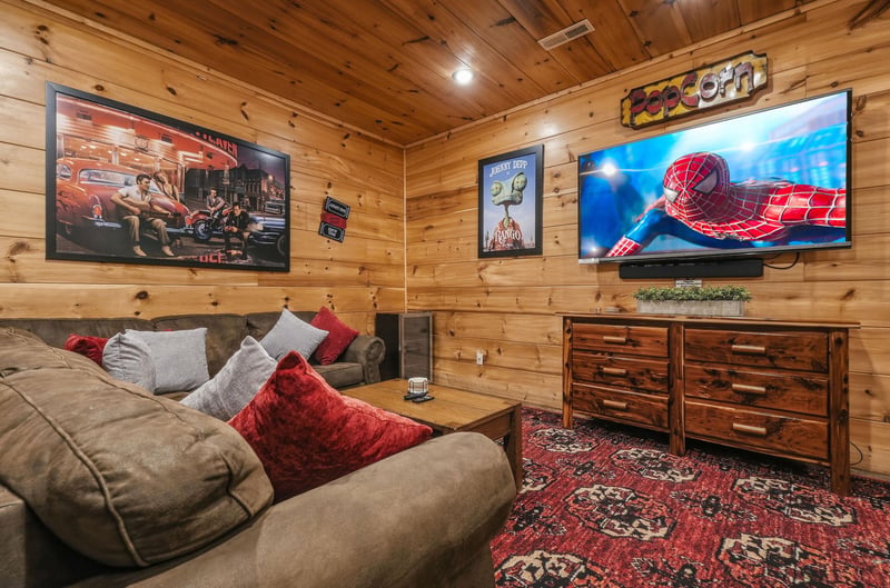 Sink into plush couches and enjoy movie night in this cozy woodpaneled media room, complete with a big screen and fun decor.