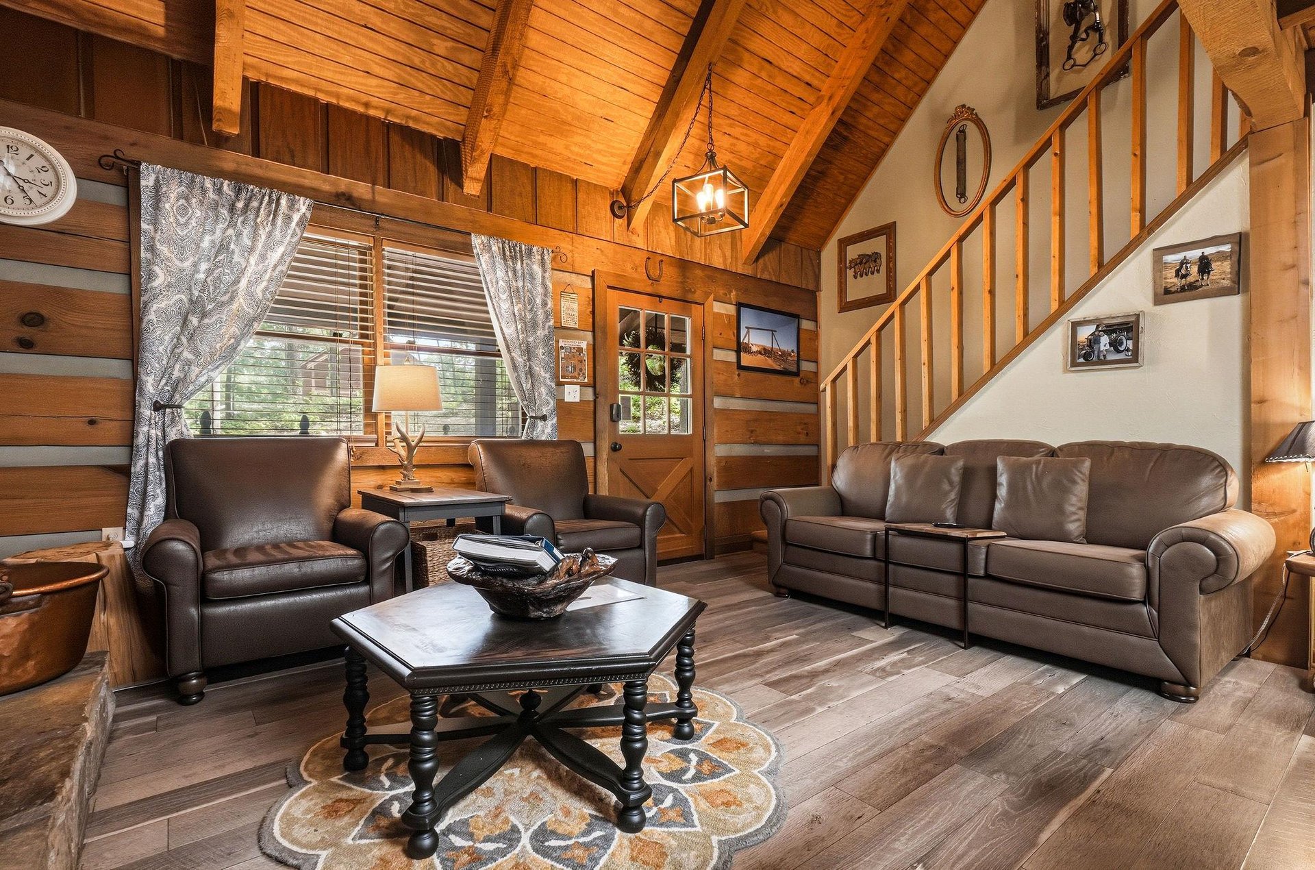 Settle into the warmth of this inviting cabin living room, where vaulted wood ceilings and rich leather seating create your perfect mountain retreat.