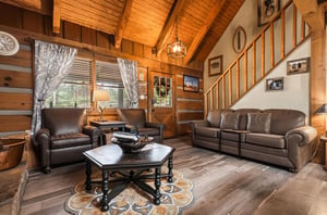 Settle into the warmth of this inviting cabin living room, where vaulted wood ceilings and rich leather seating create your perfect mountain retreat.