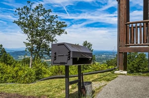 Enjoy mountain views and fresh air while grilling outdoors on the expansive grounds, surrounded by rolling hills and bright summer skies.