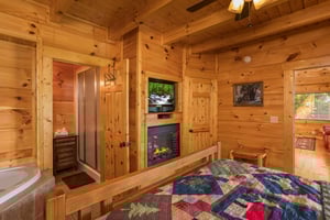 Fireplace, TV, and jacuzzi in a bedroom at Graceland, a 4bedroom cabin rental located in Pigeon Forge