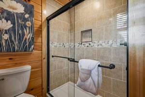 Step into your private bathroom with a beautifully tiled shower, soft towels, and charming rustic touches that invite relaxation after a day of adventure.