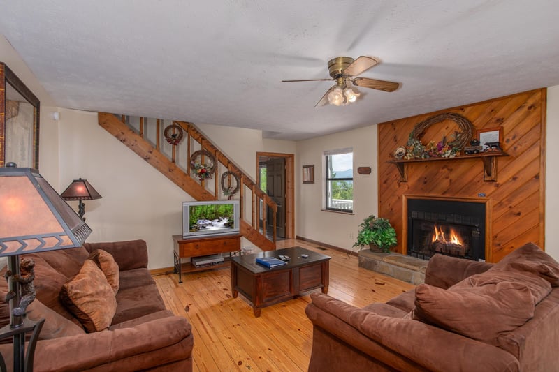 Fireplace with a wooded surround in the living room at Black Bear Ridge, a 3bedroom cabin rental located in Pigeon Forge