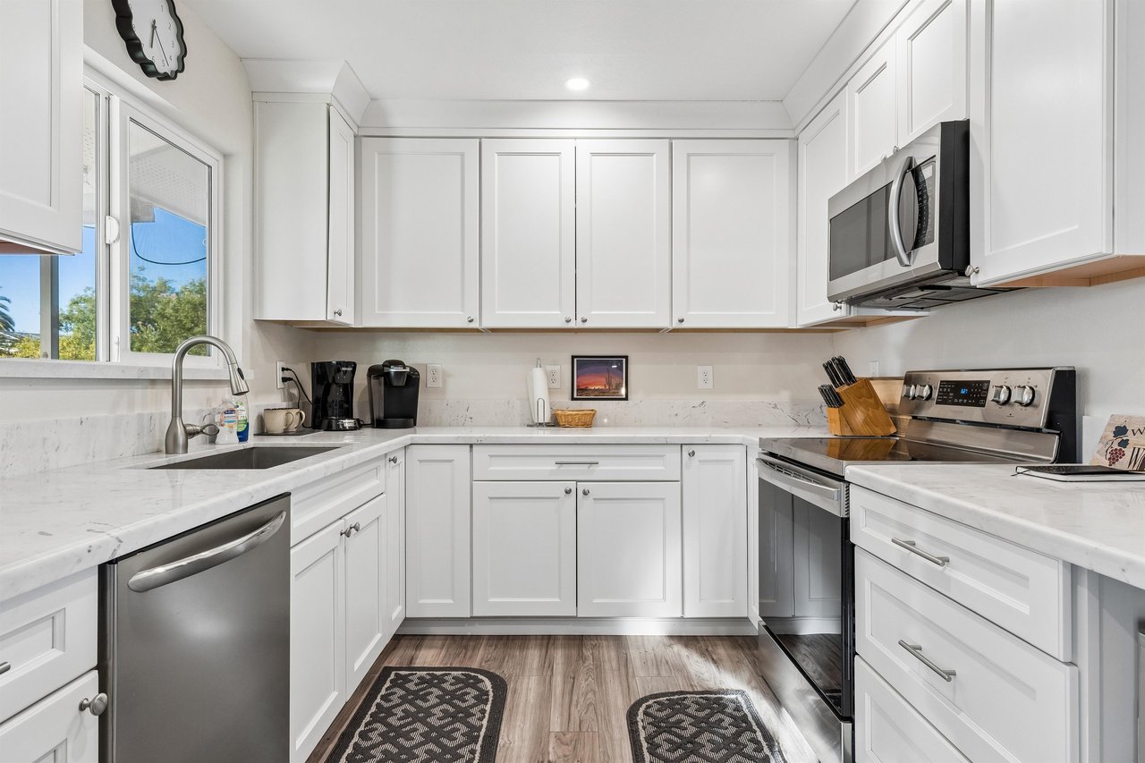 Stainless steel appliances, wine fridge, counter seating for 2, and cooking essentials.