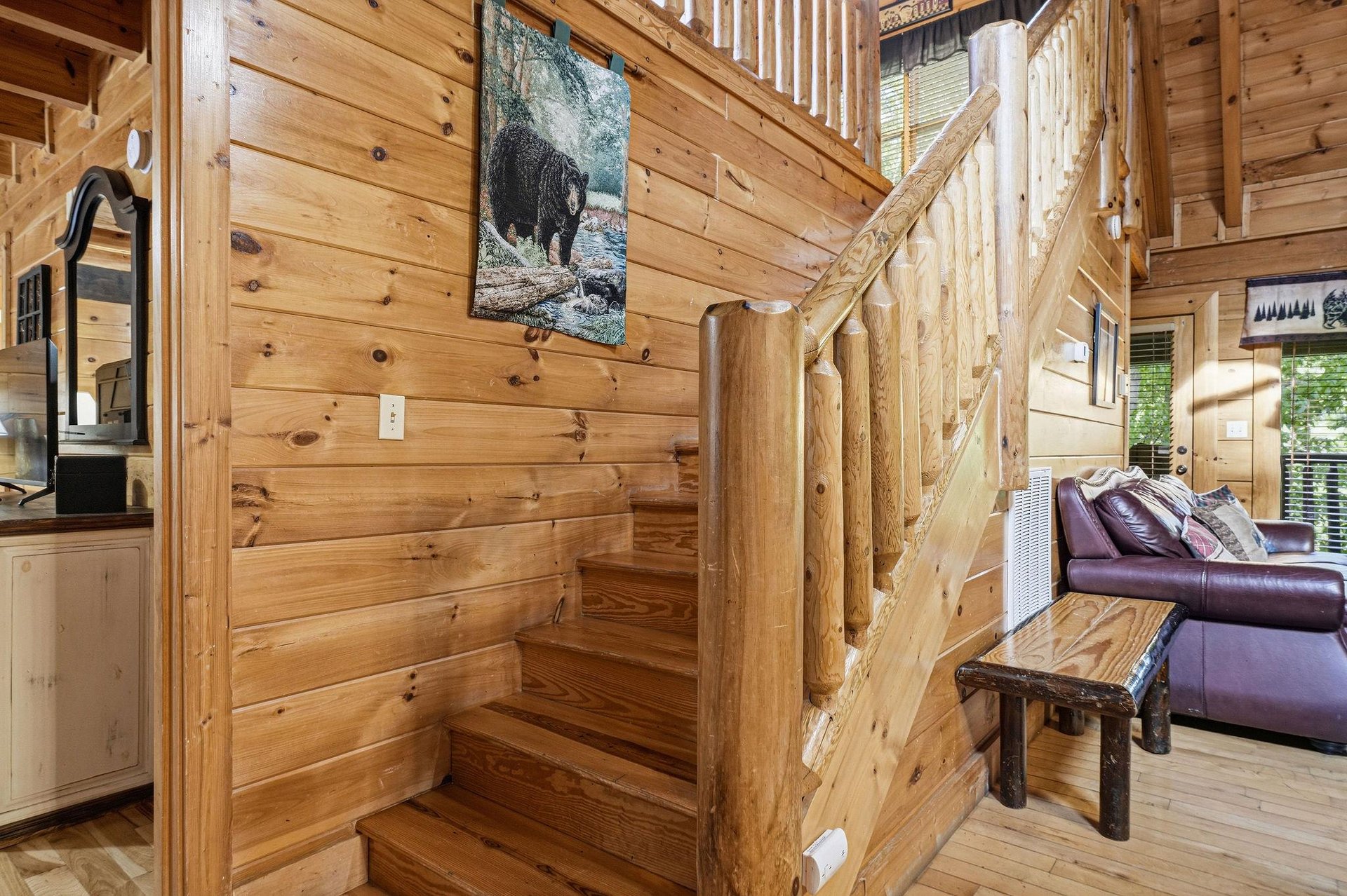Rustic log staircase invites you to explore your cozy cabin retreat, with handcrafted railings and warm wood surrounding your mountain getaway.