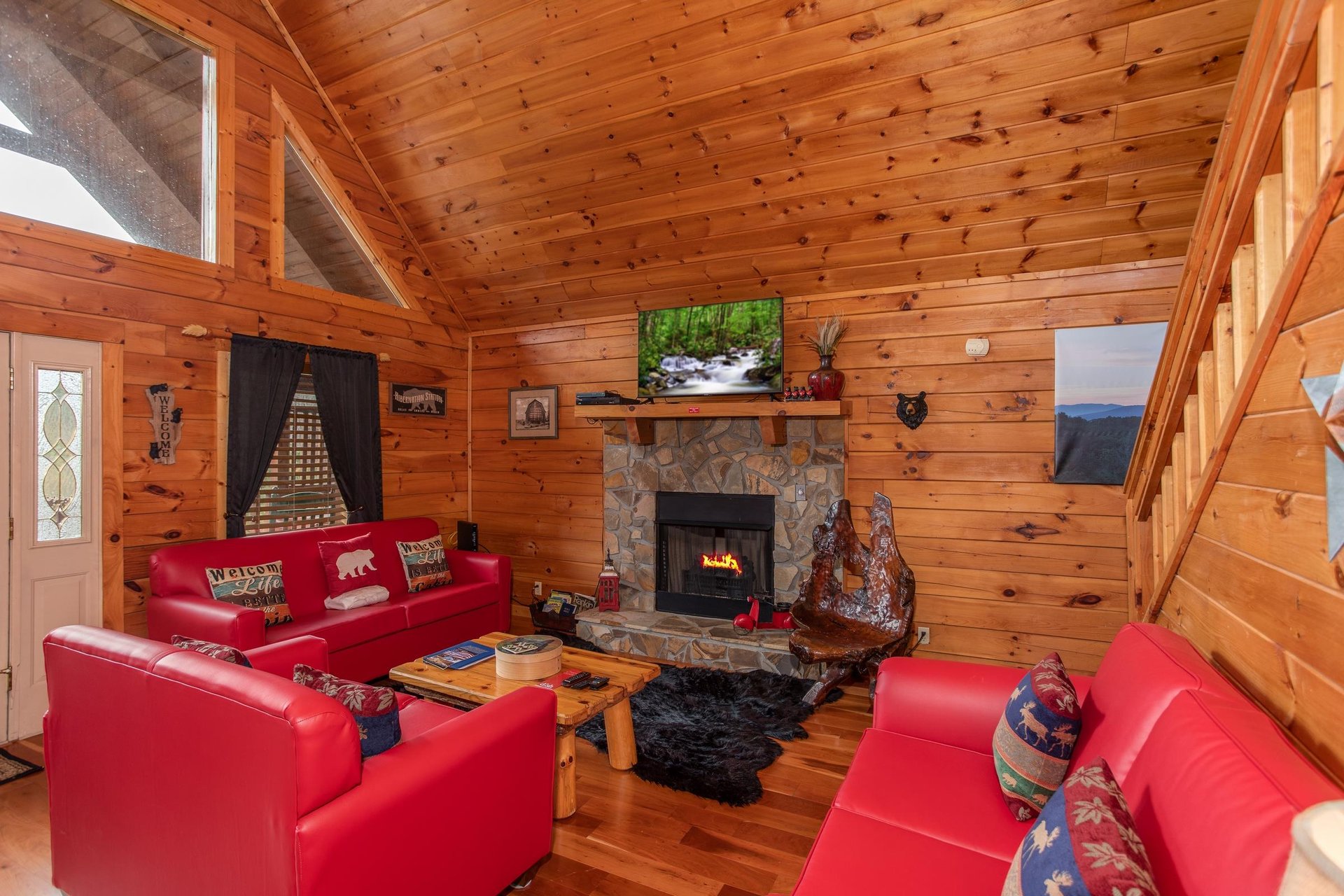 Living room with a sofa, loveseat, chair, fireplace, and Smart TV at Hibernation Station, a 3bedroom cabin rental located in Pigeon Forge