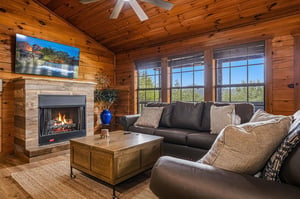Cozy up by your private fireplace as natural light pours through expansive windows framing mountain vistas. The warm timber ceilings and plush seating create your perfect retreat.