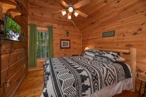 Bedroom with king bed and TV at Logans Smoky Den, a 2 bedroom cabin rental located in Pigeon Forge