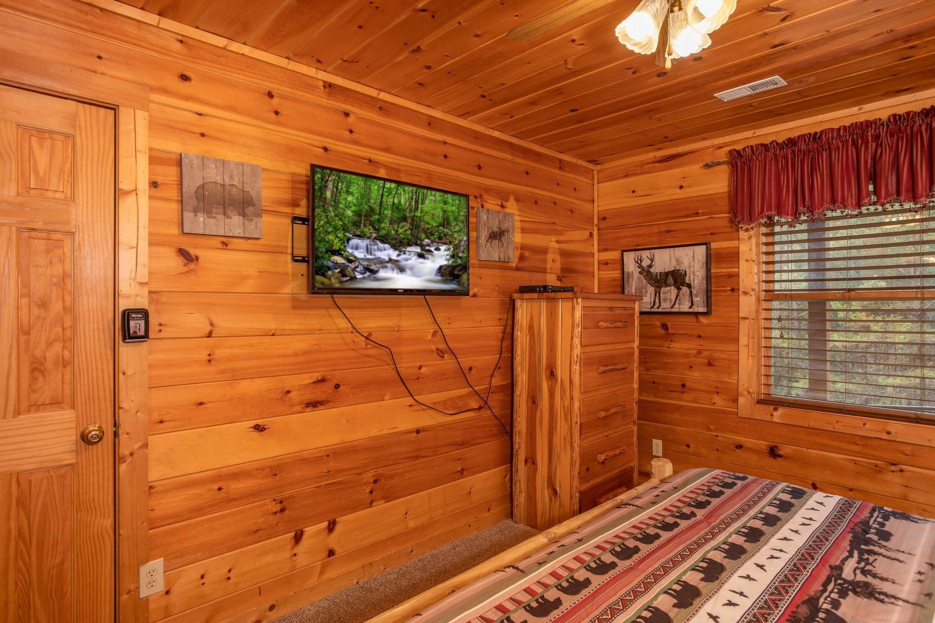 King bedroom with a TV and dresser at Hibernation Station, a 3bedroom cabin rental located in Pigeon Forge