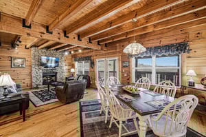 Gather around your rustic dining table where warm wood beams frame memorable meals and cozy evenings by the stone fireplace.
