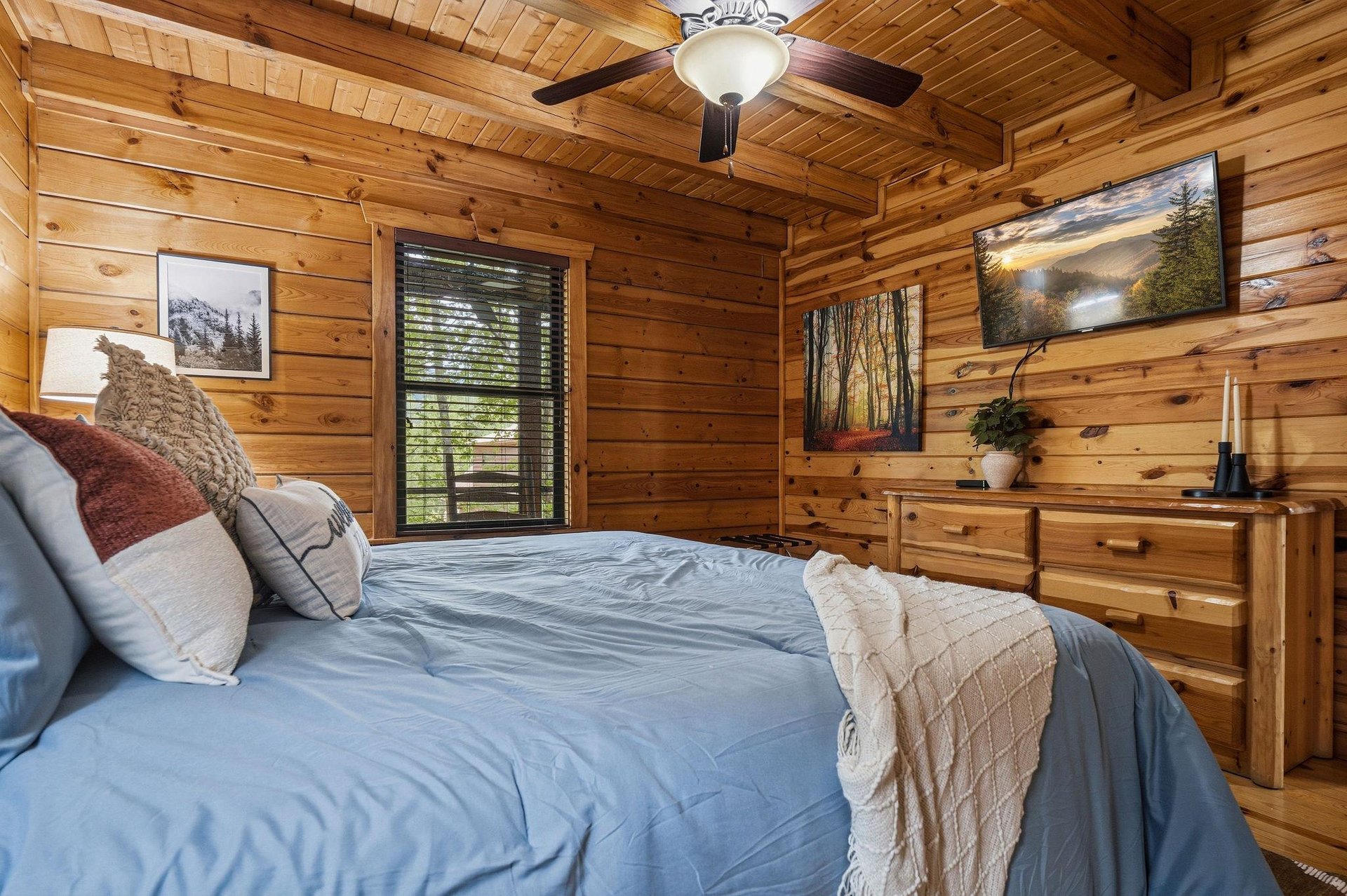 Cozy up in your rustic cabin bedroom surrounded by warm wood walls, soft linens, and nature artwork.