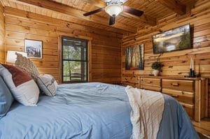 Cozy up in your rustic cabin bedroom surrounded by warm wood walls, soft linens, and nature artwork.