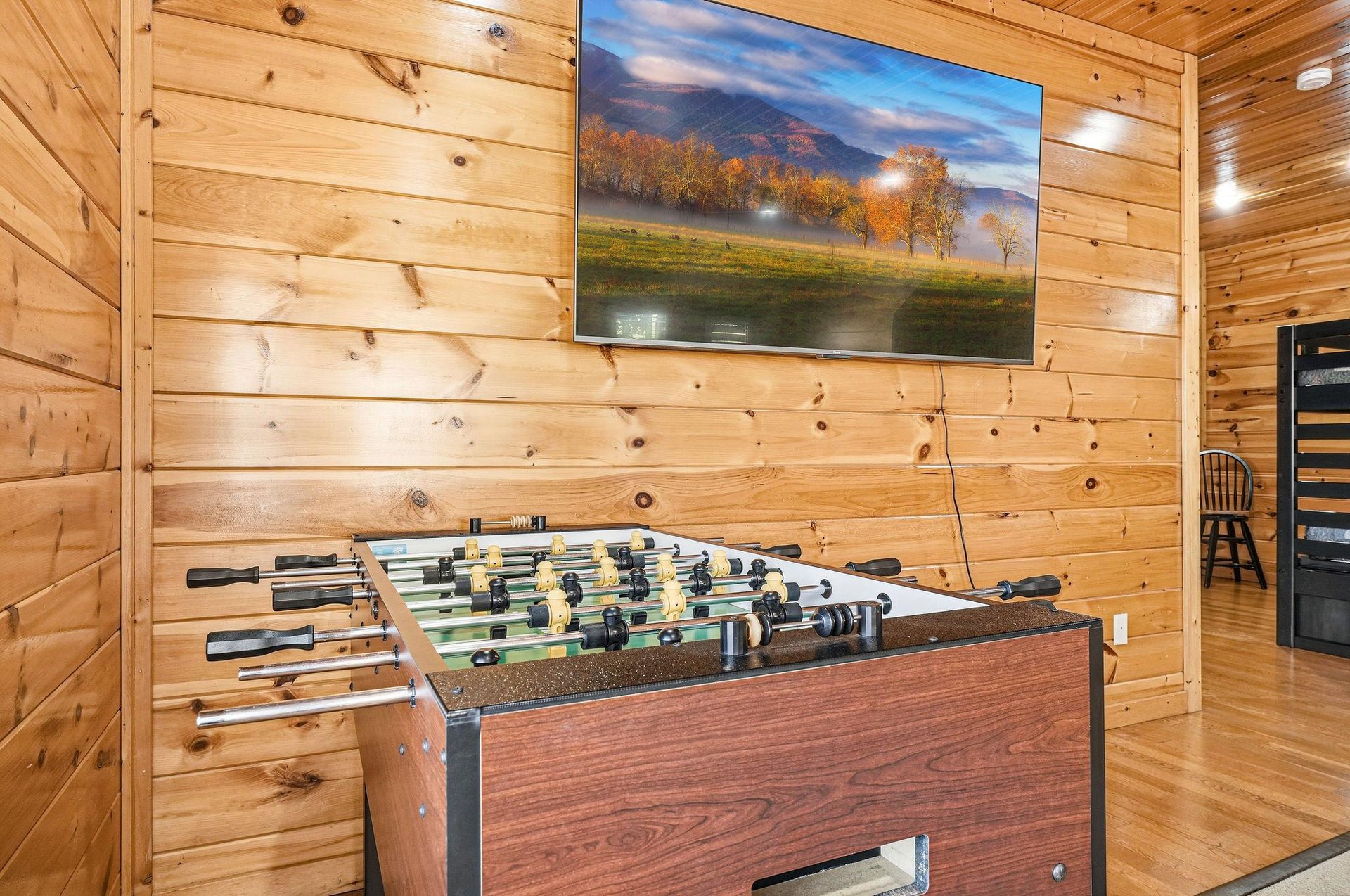 Challenge friends to foosball while catching the game on your big screen in this cozy cabin game room.