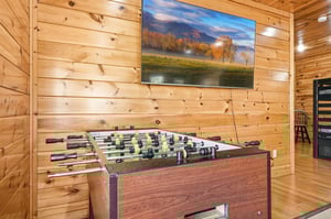 Challenge friends to foosball while catching the game on your big screen in this cozy cabin game room.