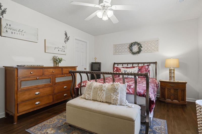 Rest easy in your peaceful retreat, where warm wood tones and thoughtful touches create a cozy sanctuary. The ceiling fan ensures comfort while you unwind beneath soft bedding.