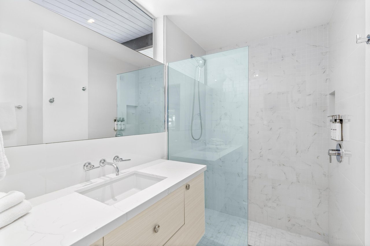 Step into your sleek modern bathroom featuring pristine marble tiles, a luxurious walkin shower, and elegant fixtures for your relaxation.