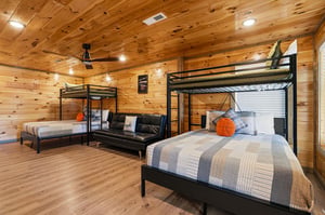 Cozy up in your rustic bunk room featuring comfortable beds and warm wood accents throughout.