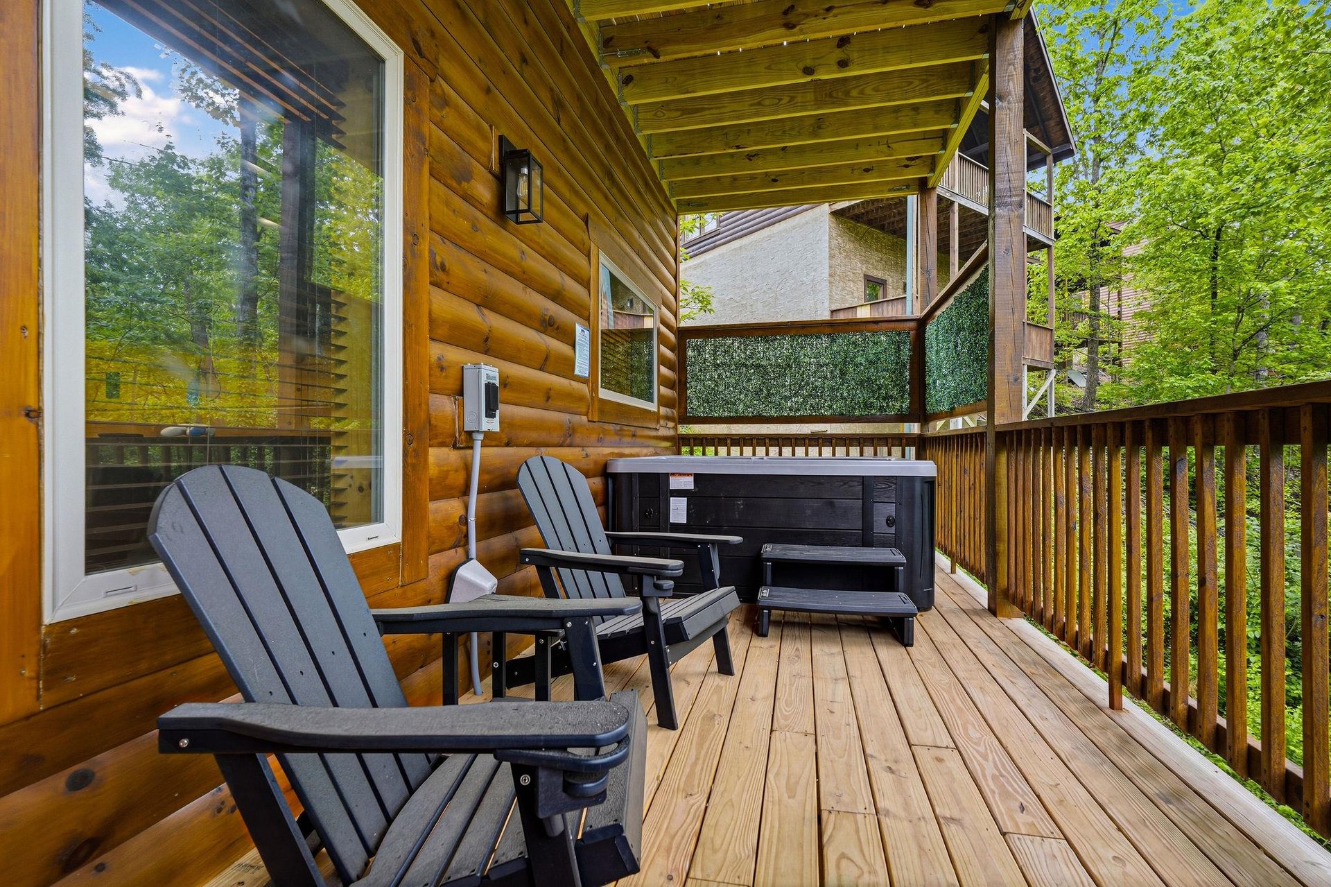 Unwind on your private deck with forest views, featuring comfy Adirondack chairs and a hot tub for ultimate relaxation.