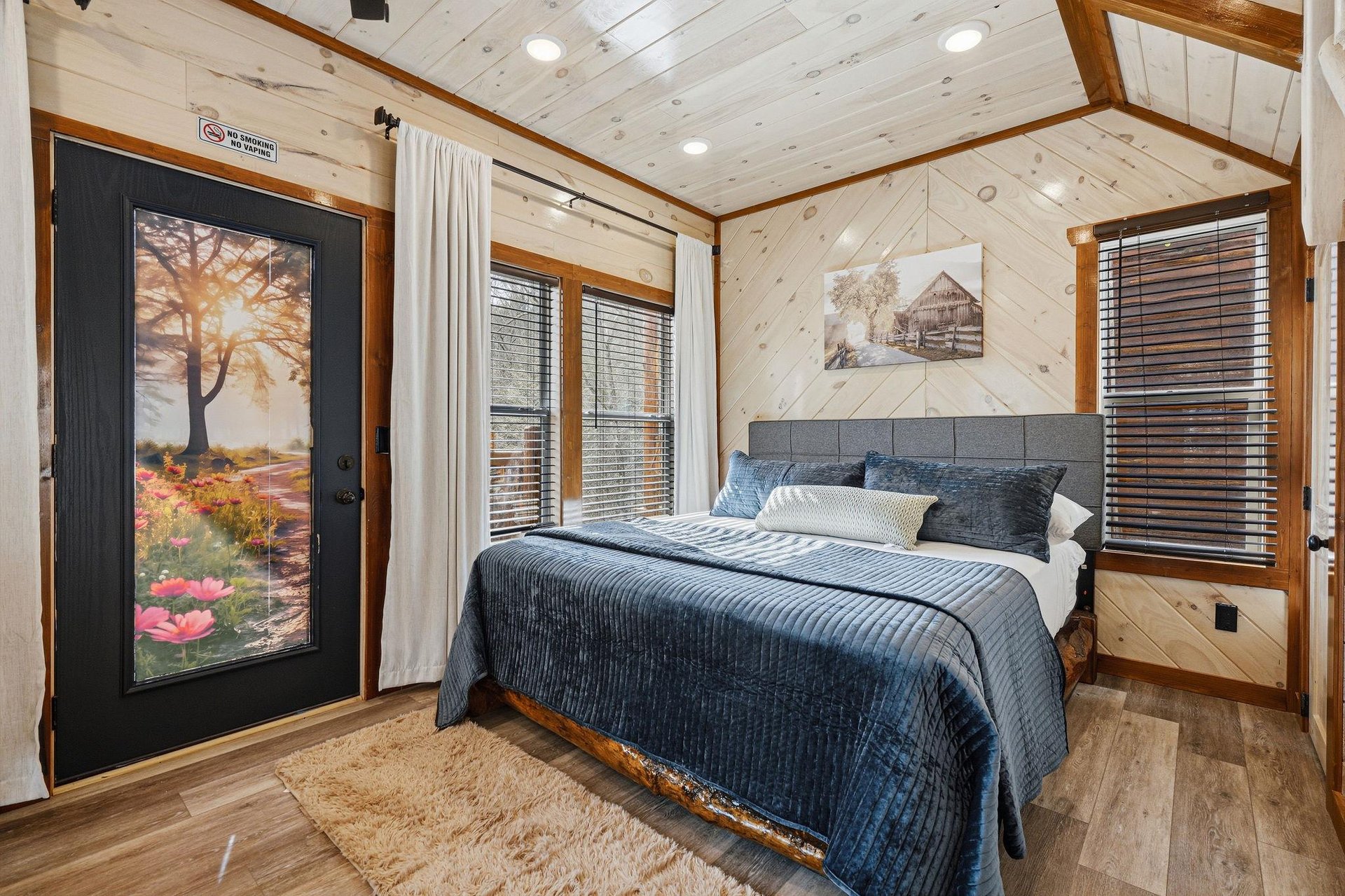 Drift off to sleep in your rustic bedroom featuring warm wood accents and cozy blue bedding.