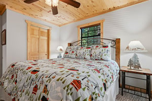 Your cozy retreat with a plush bed, warm wood accents, and charming rustic details invites you to unwind after a day of adventure.