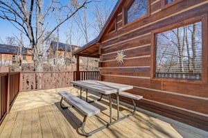 Your private deck beckons with a picnic table perfect for morning coffee or evening meals, surrounded by peaceful forest views.