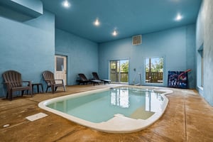 Soak away your cares in your private indoor pool, complete with lounge chairs and serene natural light streaming through large windows—perfect for relaxing any time of year.